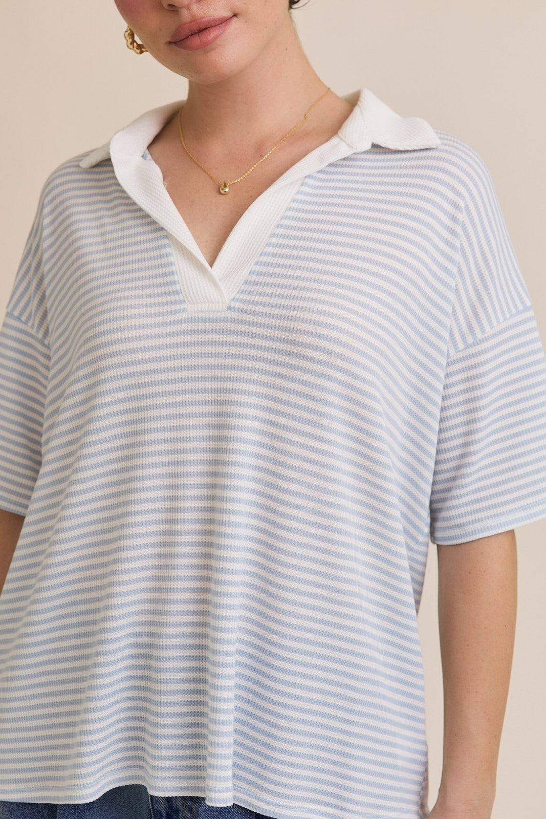 A blue and white striped polo shirt with a drop shoulder sleeve