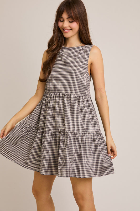 A classic boatneck tiered dress featuring a black and  tan gingham