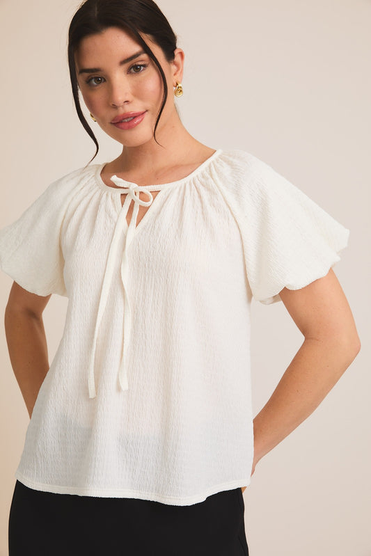 A notch front tie top with a slight puff sleeve&nbsp;