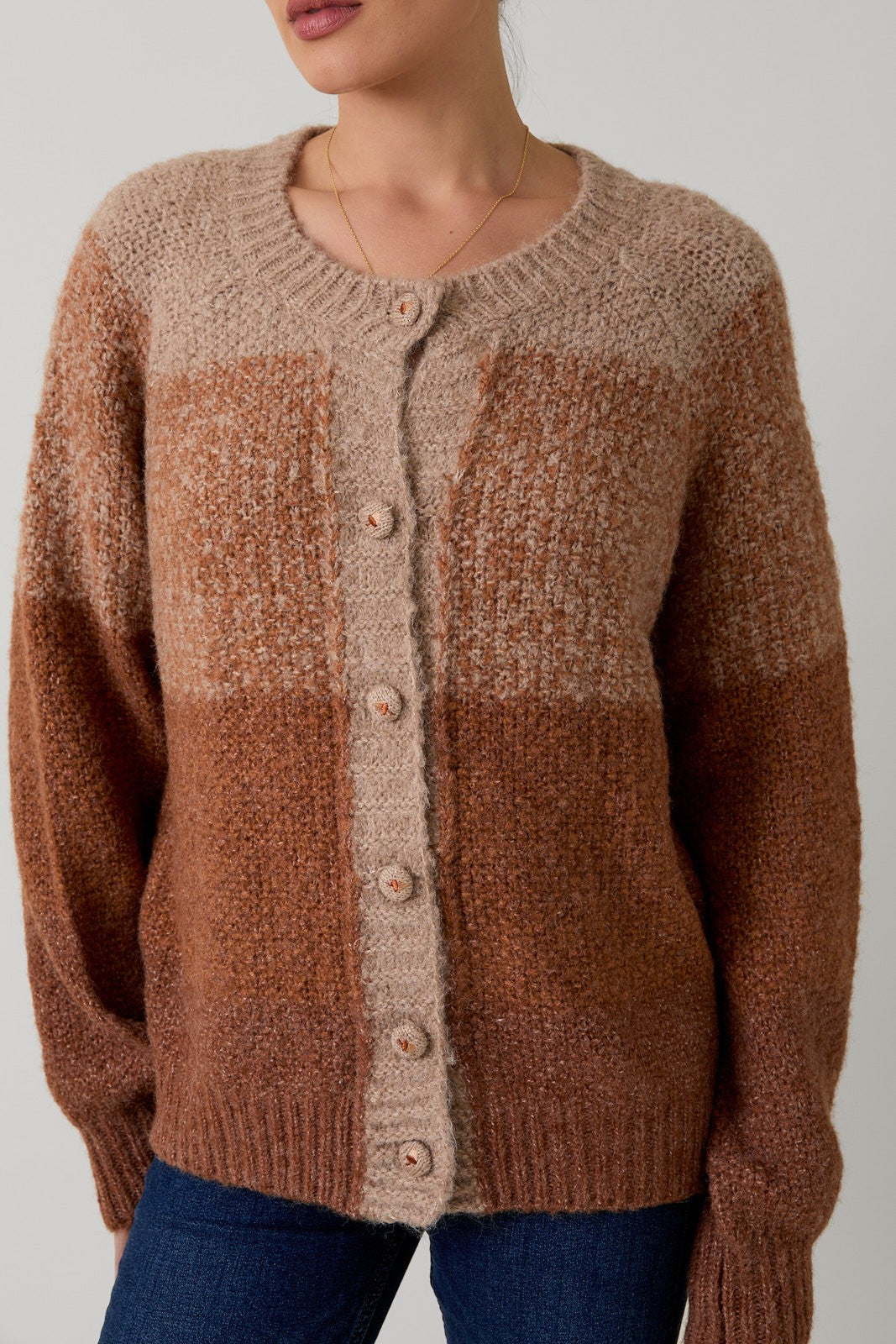 Brown checkered sweater with button details on a neutral background