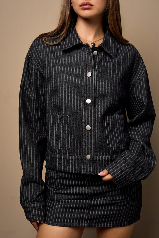 a dark denim jacket with a white stripe detail.